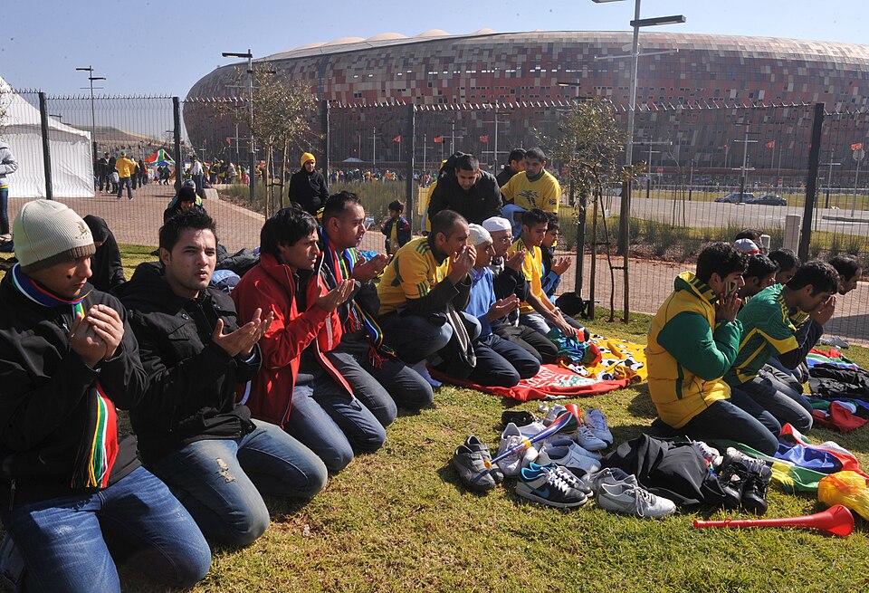 Hinchada local con banderas en un estadio brasileño